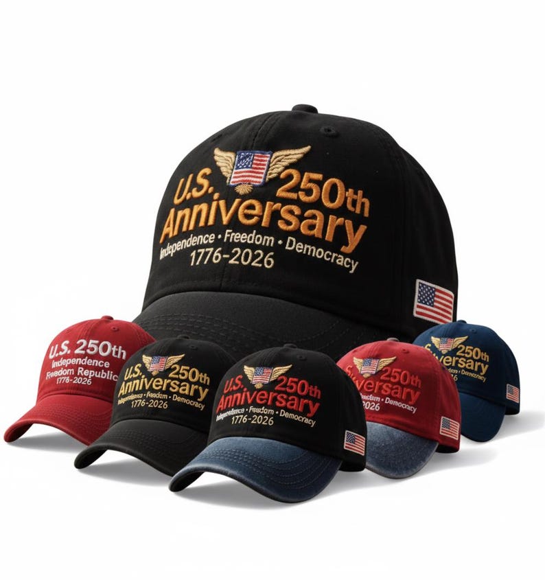 May include: A collection of baseball caps in various colors, including black, red, and navy blue. Each cap features the text "U.S. 250th Anniversary" with an American flag design and the years 1776-2026. The caps are embroidered.