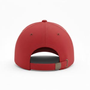 May include: A solid red baseball cap, viewed from the back, with a curved brim and a metal clasp closure. The cap has a classic six-panel design with a button on top. The adjustable strap allows for a comfortable fit.