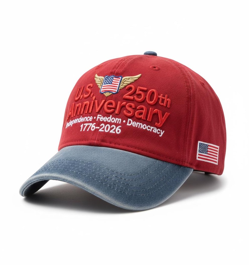 May include: A red and blue baseball cap with the text "U.S. 250th Anniversary" embroidered in white. The cap features an American flag and the years 1776-2026.