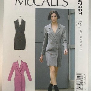 May include: McCall's M7997 sewing pattern envelope featuring a double-breasted blazer dress design. The front shows a grey plaid long-sleeve version, a black sleeveless version labeled A, and a pink long-sleeve version labeled C. Size A5 (6-8-10-12-14).