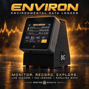May include: The ENVIRON environmental data logger is a black, square-shaped electronic device with a digital screen displaying sensor readings. It is mounted on a black, angled stand featuring the S:G logo and the text M5 on the side.