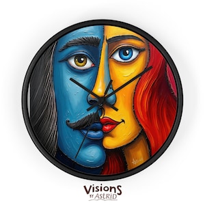 May include: A round wall clock with a black frame. The clock face features a split design of two faces, one blue and one yellow, with a mustache and red lips. The clock hands are black. The text "Visions by Astrid" is at the bottom.