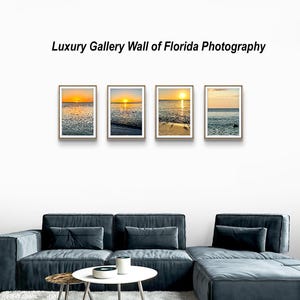 May include: A gallery wall featuring four framed photographs of Florida sunsets. Each image captures the sun setting over the ocean, with vibrant orange and yellow hues reflecting on the water. The text "Luxury Gallery Wall of Florida Photography" is above the framed photos.