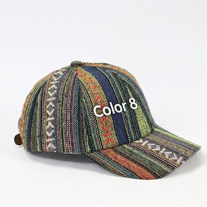 Peut inclure: Casquette de baseball avec un motif tissé coloré dans les tons de bleu, vert, orange et rouge. Le texte "Color 8" est brodé sur le devant. La casquette a une visière incurvée et une sangle réglable.