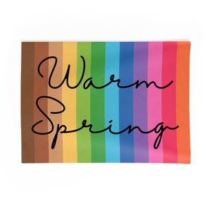 May include: A rectangular, multi-colored textile with the words "Warm Spring" in black script. The background features vertical stripes in shades of brown, yellow, green, blue, pink, and orange. The overall design is bright and cheerful.