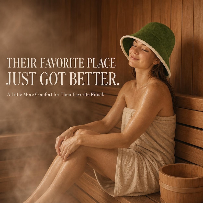 May include: A dark green bucket hat with a white trim worn in a sauna. The text on the image reads: THEIR FAVORITE PLACE JUST GOT BETTER. A Little More Comfort for Their Favorite Ritual. The hat is made of a soft, towel-like fabric material.