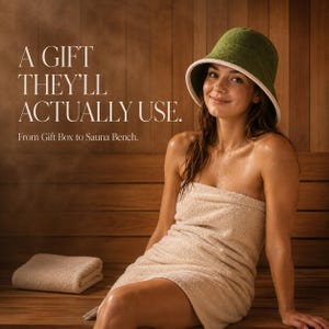 May include: A dark olive green bucket hat with a white trim, paired with a beige towel wrap. The image includes the text: A GIFT THEY'LL ACTUALLY USE. From Gift Box to Sauna Bench. The items are displayed in a wooden sauna environment with steam.