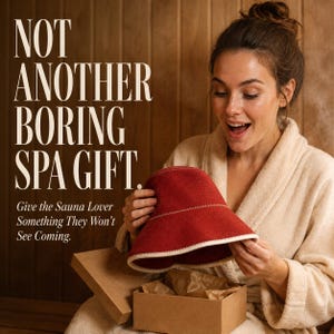 May include: A red felt sauna hat with a cream-colored stitched trim, held above an open cardboard gift box. The text on the image reads: NOT ANOTHER BORING SPA GIFT. Give the Sauna Lover Something They Won't See Coming.