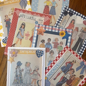 May include: A collection of vintage sewing patterns, each framed with decorative borders and embellishments. The patterns feature illustrations of clothing designs, with various brands like Simplicity, Butterick, and McCall's. Embellishments include bows, stars, and hearts.