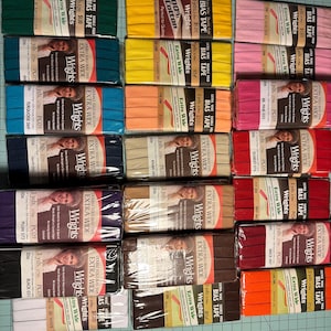 May include: A collection of Wrights Extra Wide Double Fold Bias Tape in various colors, including green, yellow, pink, blue, orange, and red. Each package is 3 yards long.