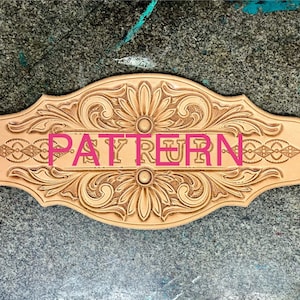 May include: A light brown leather pattern featuring floral and geometric designs. The word "PATTERN" is visible in the centre. The edges are curved, and the overall shape is elongated.