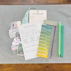 May include: A stationery set including a book review sheet, a book tracker bookmark, a magnetic bookmark, a highlighter, a black gel pen, a colored gel pen, a pack of annotation tabs, and six stickers with text like read, books, and slow burn.