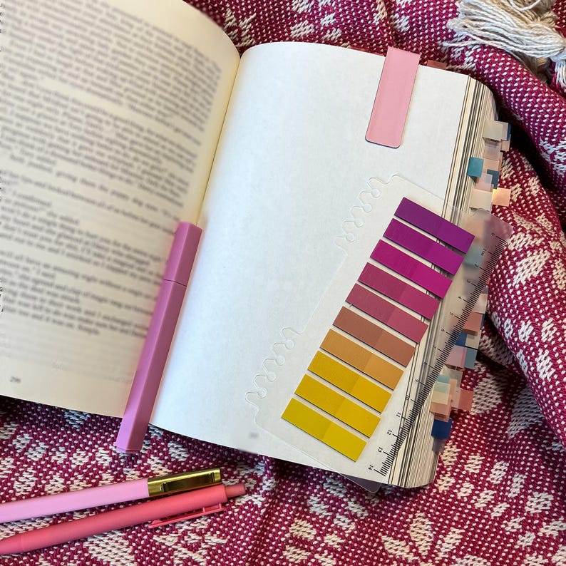 book with pink annotation set, tabs, highlighter, pen, pen, magnetic bookmark, blanket