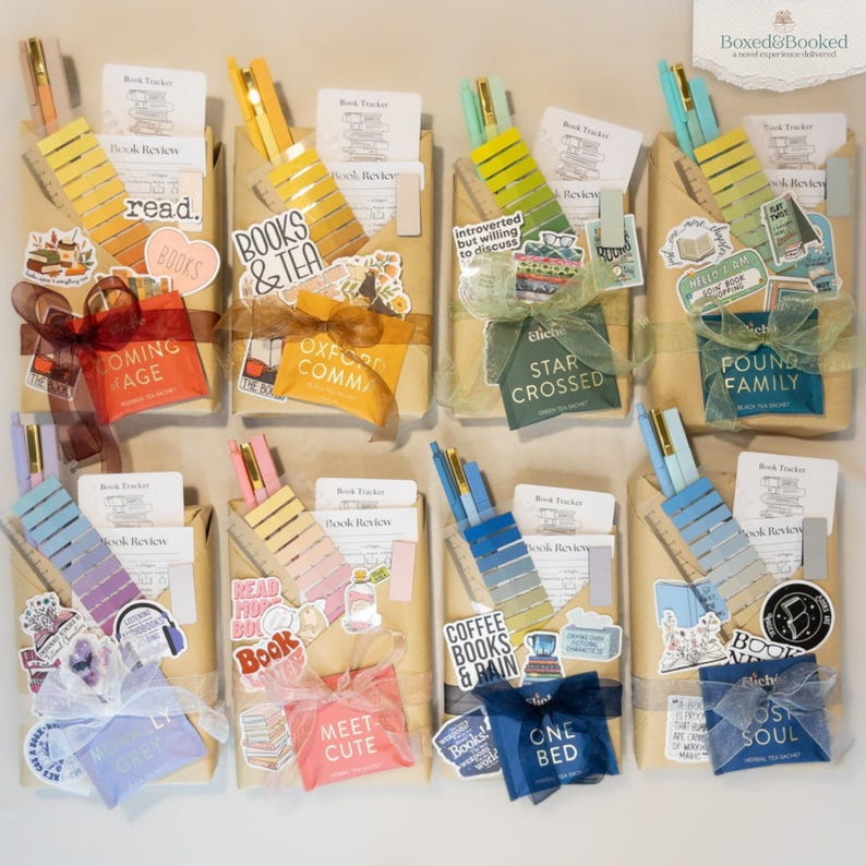 Puede incluir: Una vista cenital de varios regalos envueltos, cada uno adornado con elementos decorativos. Cada paquete incluye un bol&iacute;grafo, un marcap&aacute;ginas y pegatinas con temas de libros. Los regalos est&aacute;n atados con cintas y lazos de varios colores.