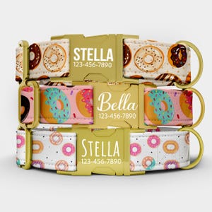 Puede incluir: Tres collares para perros con hebillas doradas. Los collares presentan patrones de donuts en varios colores, incluyendo rosa, marrón y turquesa. Cada collar tiene un nombre y un número de teléfono impresos en la hebilla.