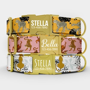 May include: Three personalized dog collars with gold hardware. The top collar is mustard yellow with cheetahs and black leaf designs. The middle collar is pink with cheetahs and tigers. The bottom collar is white with a floral and cheetah print. Each collar has a name and phone number.