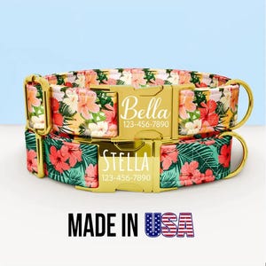 May include: Two dog collars with floral patterns and gold-colored hardware. One collar is labeled "Bella" and the other "Stella", each with a phone number. The collars have a tropical flower design with the text "MADE IN USA".