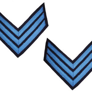 May include: Two blue and black chevron patches, each with three stripes. The patches are in a V-shape, with the blue stripes outlined in black. The background is white.