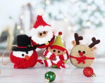 May include: A collection of handmade crochet Christmas ornaments. The ornaments include a snowman, Santa Claus, an elf, and a reindeer. Each ornament is detailed with various colors and textures, and has a string for hanging. A green and red ornament are also present.