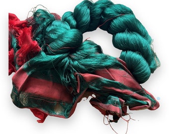 Thrum Seidenfasern. reine Seide mit angebrachtem gewebtem Sari-Seidenstoff. Spinnen, Sticken, Nähen. Smaragdgrün, rot.