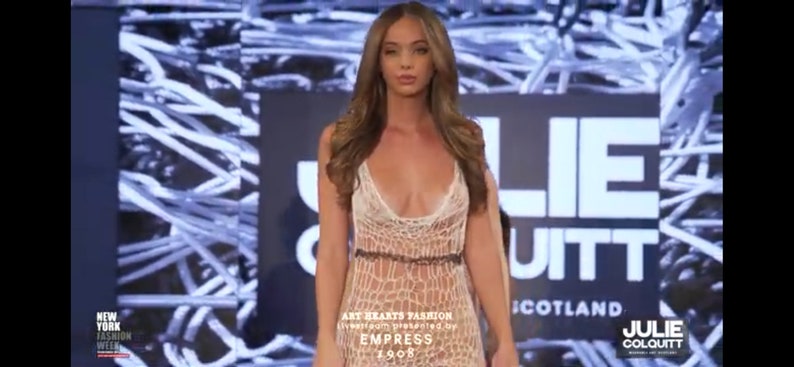 Peut inclure: Une robe longue sans manches en crochet blanc transparent avec un motif ajour&eacute;, un d&eacute;collet&eacute; en V profond et une fine bande horizontale sombre &agrave; la taille. Le v&ecirc;tement pr&eacute;sente un corsage ajust&eacute; qui se prolonge par une jupe fluide et textur&eacute;e.