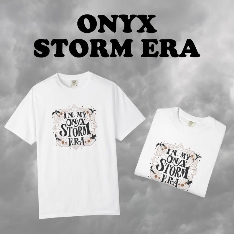 May include: Two white t-shirts with the text "ONYX STORM ERA" above the shirts. The shirts have a graphic that says "IN MY ONYX STORM ERA" in a decorative frame. The background is a cloudy gray.
