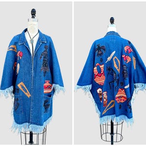 May include: A denim jacket with a blue wash, featuring fringe trim and colorful embroidered Native American-inspired designs. The jacket has long sleeves and a collared neckline. The back of the jacket also has embroidered designs.