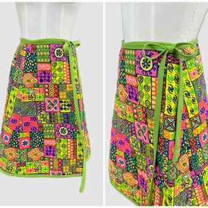 Peut inclure: Une jupe portefeuille avec un motif patchwork vibrant composé de carrés rose fluo, vert citron, jaune, orange et bleu. La jupe présente une ceinture et des bordures en tissu vert citron, avec de longs liens assortis noués sur le côté.