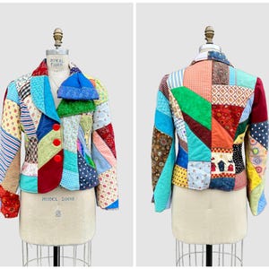 May include: A white ceramic mug with a black handle and the text "But First, Coffee" in a bold, black font. The mug is filled with a dark liquid, likely coffee, and sits on a light-colored surface.