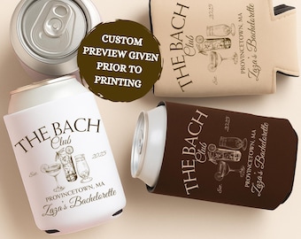 May include: An overhead shot features two beverage cans and three can coolers. The coolers are white, tan, and brown, each printed with "THE BACH Club" and "Zaza's Bachelorette" text. The image includes a custom preview notice.