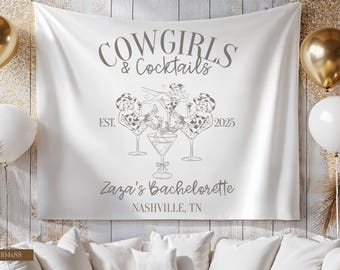 Könnte beinhalten: Weißes Stoffbanner mit dem Text "Cowgirls & Cocktails" und Illustrationen von Cowgirl-Figuren in Martinigläsern. Das Banner enthält auch "Est. 2025" und "Zaza's Bachelorette, Nashville, TN."