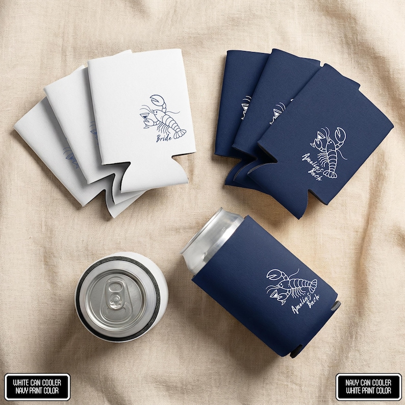 May include: A collection of white and navy blue foam can coolers featuring a white or navy blue line art illustration of a lobster holding a drink. Some coolers display the text Bride or Amelia's Bach. One navy cooler is shown on a metal can.