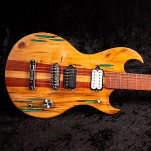 May include: A custom electric guitar with a unique design. The body features a combination of light and dark wood, with green accents. The neck and headstock are a darker wood, and the guitar has multiple pickups and tuning pegs.