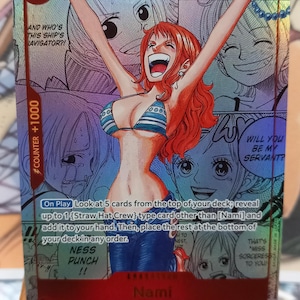 May include: A holographic trading card featuring Nami from One Piece. The card shows Nami with her arms raised, smiling. The card has text that reads "COUNTER +1000" and "2000 SPECIAL".