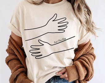 Camiseta "Siente el abrazo": Camiseta con colores cómodos y diseño dibujado a mano
