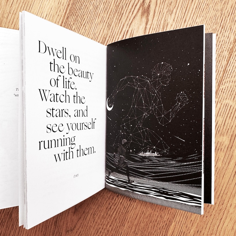 Op de afbeelding: Een open boek met een zwart-witte illustratie van een persoon die onder een sterrenhemel rent. De tekst op de linkerpagina luidt: "Dwell on the beauty of life. Watch the stars, and see yourself running with them."