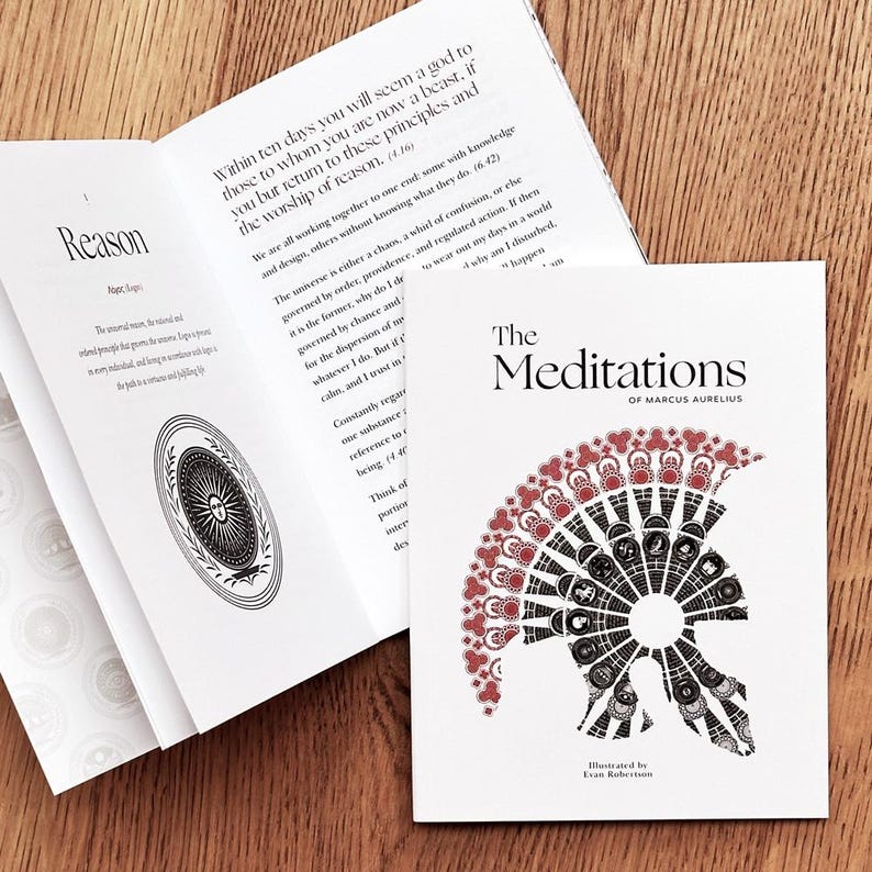 Op de afbeelding: Een wit boek met de titel "The Meditations of Marcus Aurelius" in zwarte tekst. De omslag heeft een rode en zwarte illustratie van een helm.