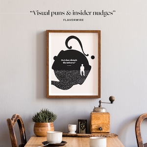 May include: A black and white illustration of a teapot with the text "Do I dare disturb the universe?" printed on the side. The illustration is framed in a brown wooden frame and hanging on a light gray wall.