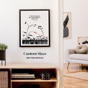 Puede incluir: Una impresi&oacute;n de arte en blanco y negro con una cita sobre labios que rozan como flores silvestres en el viento. La impresi&oacute;n est&aacute; enmarcada en un marco negro y est&aacute; colgada en una pared blanca. El texto dice "Their lips brushed like young wild flowers in the wind."