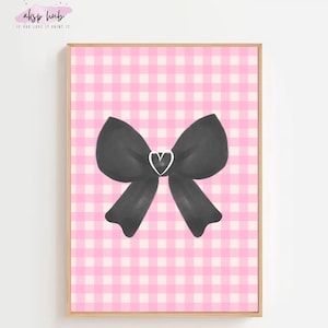 Puede incluir: Una impresión enmarcada con un lazo negro y un corazón blanco sobre un fondo de cuadros rosas y blancos. La obra de arte está en un marco de madera. La esquina superior izquierda tiene el texto "aksp hub" y "IF YOU LOVE IT PRINT IT".