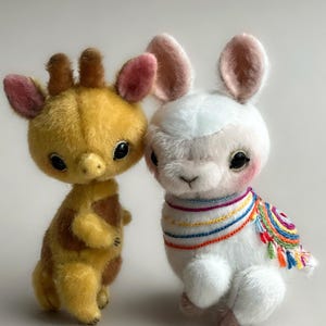 May include: Two soft toy animals: a yellow giraffe with brown patches and a white llama wearing a colourful embroidered shawl. Both have large, dark eyes and pink accents on their ears and cheeks. The giraffe stands beside the llama.