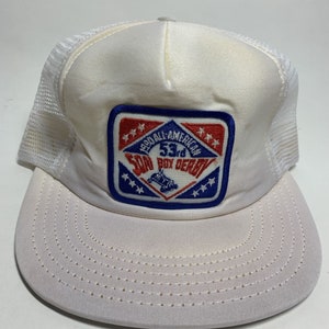 May include: White mesh trucker hat with a blue and red embroidered patch that says "Pro All-American 53rd Soap Box Derby".