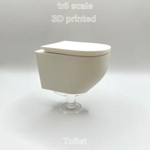 Könnte beinhalten: Eine weiße Keramik-Tasse mit schwarzem Henkel und dem Text "But First, Coffee" in schwarzer, fetter Schrift. Die Tasse steht auf einer Holzoberfläche. Die Tasse ist 10 cm hoch.