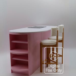 Peut inclure: Une île de cuisine rose miniature avec un comptoir blanc et une table de cuisson intégrée. Deux tabourets de bar en bois avec des coussins et des dossiers blancs et moelleux sont positionnés à côté de l'îlot. L'image comprend le texte "Digital File Only".