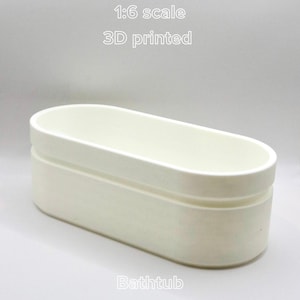May include: A 1:6 scale, 3D printed, off-white bathtub. The tub has a rectangular shape with rounded edges and a recessed base. The text "Bathtub" is printed at the bottom of the image.