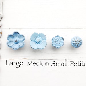 May include: Four blue flower-shaped cabinet knobs in different sizes, labeled "Large", "Medium", "Small", and "Petite".