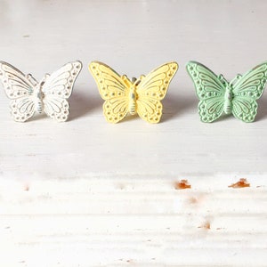 May include: Three decorative butterfly drawer pulls in white, yellow, and green.