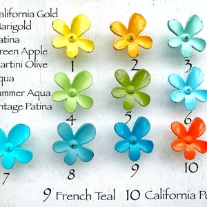 May include: A white board with ten different colored metal flower-shaped knobs. The knobs are numbered 1 through 10 and each color is labeled with a name. The colors are: California Gold, Marigold, Patina, Green Apple, Martini Olive, Aqua, Summer Aqua, Vintage Patina, French Teal, and California Poppy.
