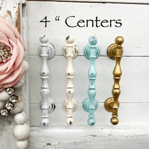 May include: Four cabinet knobs with 4" centers. The knobs are in four different colors: white, off-white, light blue, and gold.