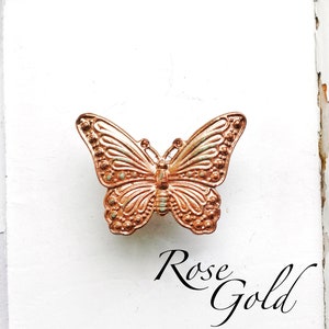 May include: Rose gold butterfly drawer pull with an ornate design.